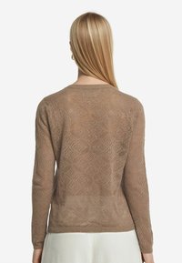 Pullover lavorato a maglia marrone chiaro con un motivo a rombi, maniche lunghe e scollatura rotonda, caratterizzato da una texture leggermente trasparente.