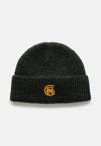 Donkergroene gebreide beanie met een geribbelde textuur en een opgerolde zoom. Heeft een oranje geborduurd logo aan de voorkant.