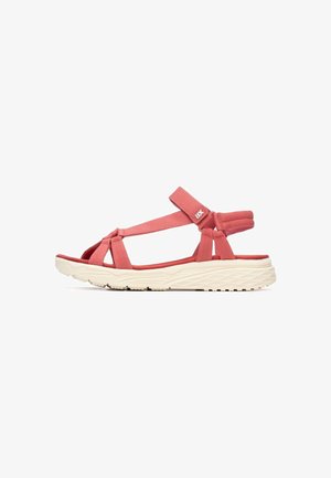 Sandalias de tela roja con correas cruzadas, correa ajustable en el tobillo y suela texturizada de color crema con un pequeño tacón para mayor altura.