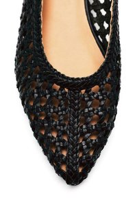 Scarpa piatta nera intrecciata con design a punta. Presenta una texture dettagliata e un motivo a intreccio aperto, che mette in mostra una fodera interna morbida.