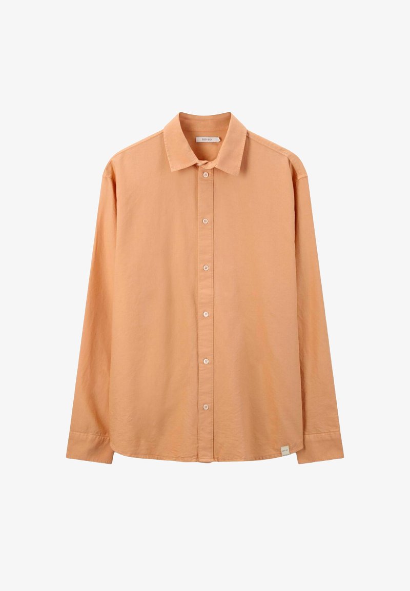 Chemise à manches longues à boutons de couleur pêche clair. Elle présente un col classique, des boutons à l'avant et une légère texture. Comprend une petite étiquette logo à l'ourlet.