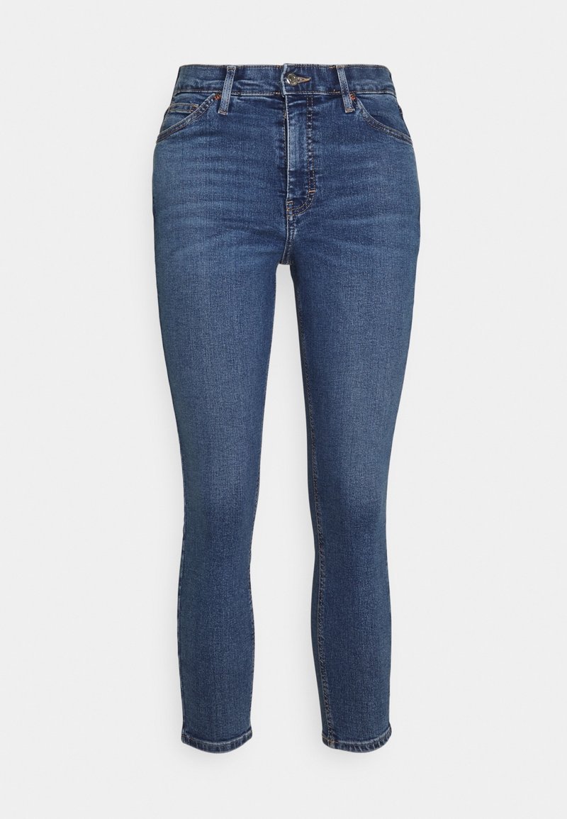Pantalones vaqueros ajustados de mezclilla azul oscuro con una textura suave, de cintura alta, con pasadores para cinturón y un dobladillo ligeramente recortado. Diseño clásico de cinco bolsillos.