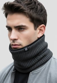 Dark gray knit snood, ribbed texture, high neck design, featuring a stitched logo tag. Worn with a gray bomber jacket over a black shirt.