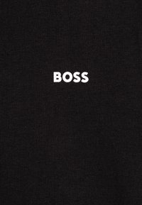 Zwarte T-shirt van zacht katoen, met een witte "BOSS"-logo gecentreerd op de borst. Gladde textuur met een regular fit.