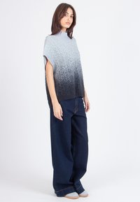 Pleteni pulover s gradijentom od svijetlosive do crne boje, kratki rukavi, текстурirani uzorak; uparen s širokim tamnim trapericama.