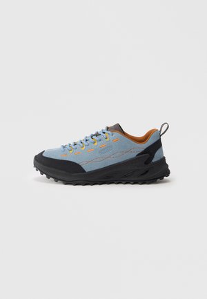Light blue suede athletic shoe with black rubber sole and accents. Orange interior and contrasting yellow laces. Features textured surface.