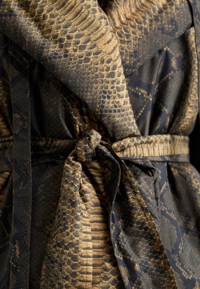 Robe de tecido com padrão de python em tons escuros de castanho e preto, apresentando um cinto atado na cintura e variações texturais no material.