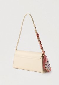 Sac à main beige clair au design structuré, avec une bandoulière tressée rose et un détail d'écharpe florale sur un côté. Texture en cuir lisse.