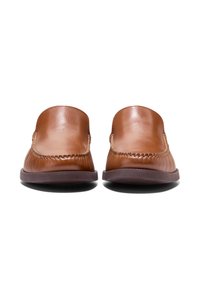 Bruna läderloafers med en slät yta, prydda med dekorativ sömnad och ett subtilt vågmönster längs kanten. Gummisålar för bra grepp.