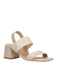 Sandali beige con tacco quadrato, design con fascetta intrecciata, punta aperta e finitura in pelle liscia. Presentano una fascetta posteriore sicura per maggiore stabilità.