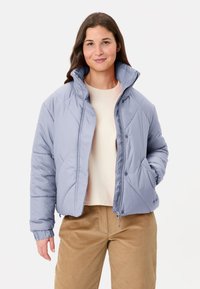 Giacca imbottita azzurro chiaro con collo alto, bottoni a pressione e tasche laterali. Presenta cuciture diagonali e polsini a coste.