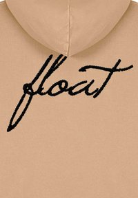 Felpa beige con texture a coste, caratterizzata da un grande design ricamato in nero "float" sul davanti e un cappuccio classico.
