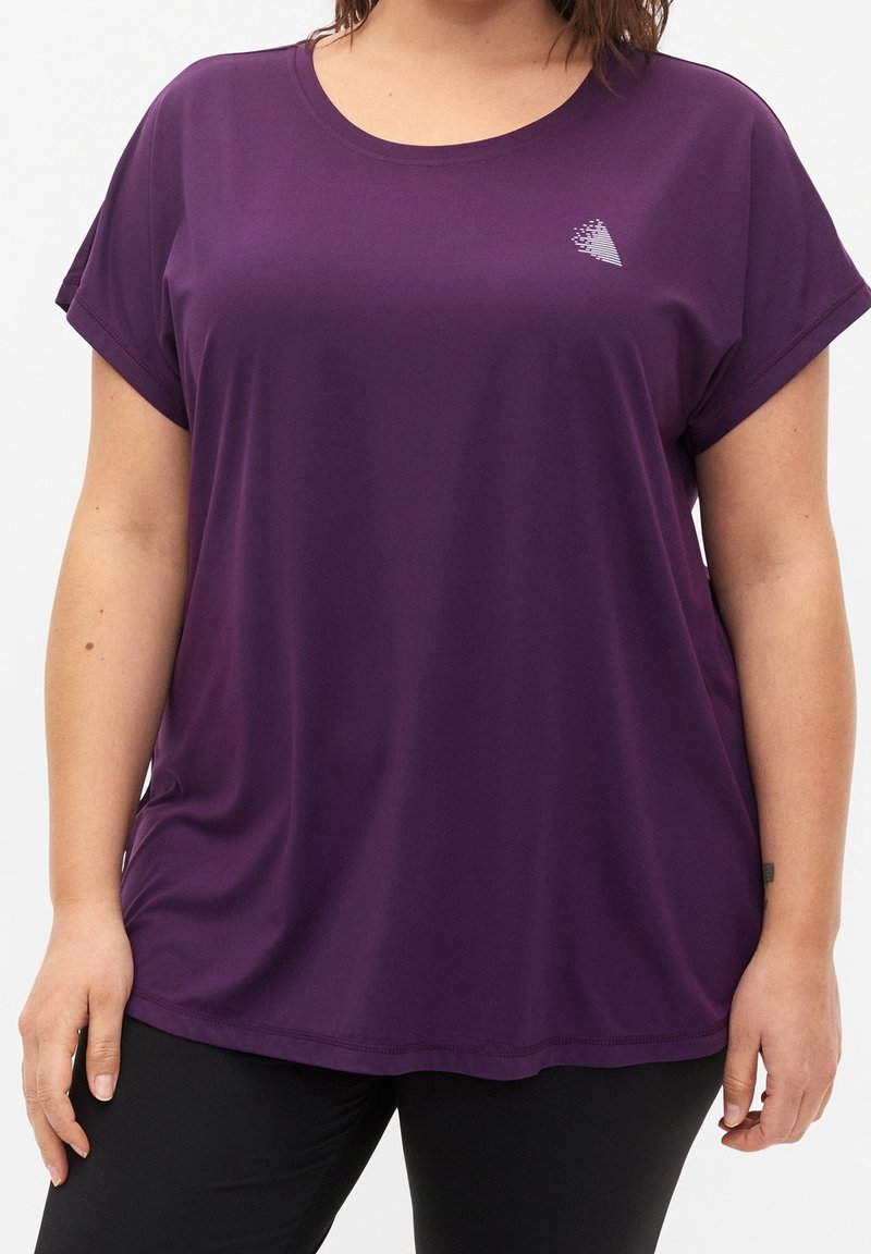 Purple short-sleeve top in a smooth, lightweight fabric. Features a round neck and a subtle graphic detail on the chest.