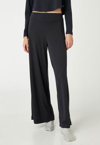 Pantalones de pierna ancha negros, hechos de una tela suave con una textura lisa, que cuentan con una cinturilla ajustada y un diseño casual y cómodo.