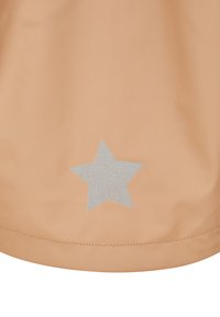 Peach-colored garment with a smooth texture features a glittery silver star accent near the hem. Simple and minimalist design.