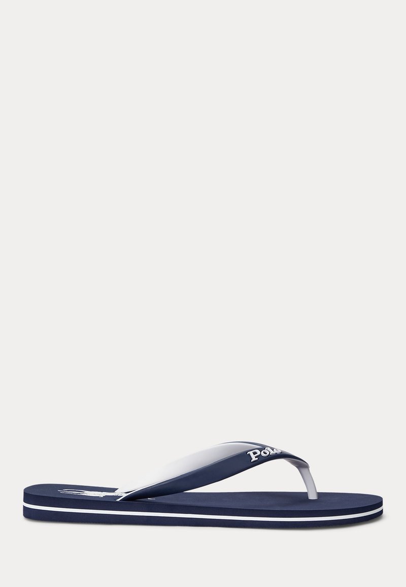 Tumši zils un balts pludmales čībiņa ar baltu logotipu uz zolītes un uzrakstu "Polo" uz siksniņas, redzama no sāniem.