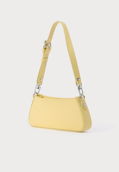 Κίτρινη δερμάτινη τσάντα χειρός με καμπυλωτό σχήμα, ρυθμιζόμενο λουρί και ασημένιες μεταλλικές λεπτομέρειες. Λεία υφή με ελάχιστα σχεδιαστικά στοιχεία.