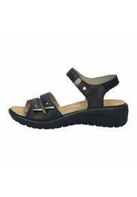 Schwarze Ledersandalen verfügen über zwei verstellbare Riemen mit silberner Hardware, eine gepolsterte Innensohle und eine niedrige Keilsohle für zusätzlichen Komfort.