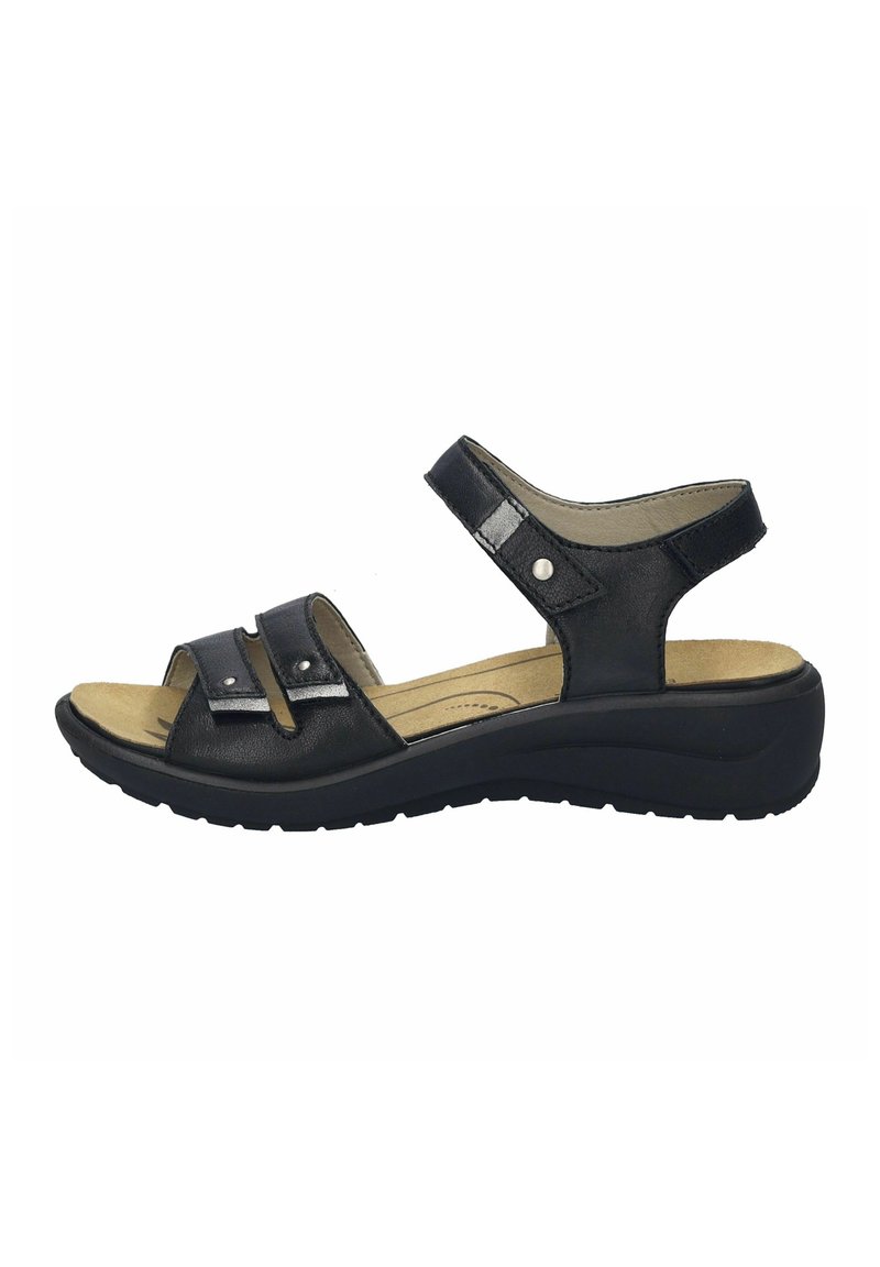 Schwarze Ledersandalen verfügen über zwei verstellbare Riemen mit silberner Hardware, eine gepolsterte Innensohle und eine niedrige Keilsohle für zusätzlichen Komfort.