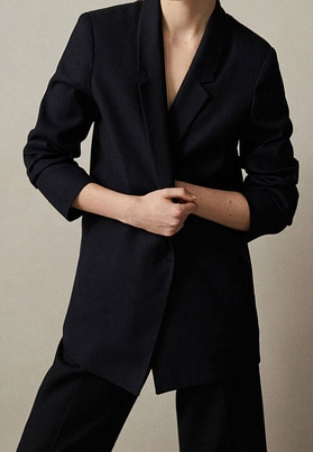 Marineblazer mit lockerem Schnitt, Ein-Knopf-Verschluss, aufgeschlagenem Revers und langen Ärmeln, aus strukturiertem Stoff gefertigt.