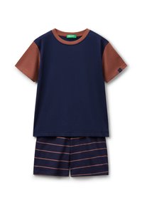 Camiseta de manga corta azul marino con mangas de color óxido y escote redondo, combinada con pantalones cortos azul marino con rayas horizontales en color óxido.