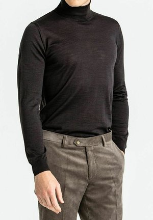 Sort højhalset top i en tætsiddende design, med lange ærmer og glat tekstur, parret med teksturerede beige corduroy bukser.