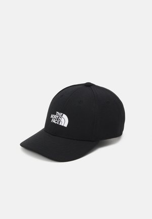 Casquette de baseball noire avec une visière incurvée, en tissu ; présente un logo brodé blanc de "The North Face" à l'avant.