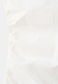 Witte, gestructureerde stof met subtiele verticale kreukels en een zacht, ongelijk oppervlakpatroon.