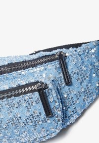 Pouch din denim de culoare albastru deschis, cu paiete argintii, două compartimente cu fermoar și accente negre. Suprafață texturată cu decorațiuni împrăștiate.