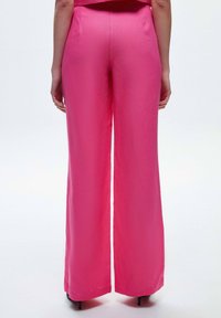 Roze wijde broek van een soepele, lichte stof. Heeft een hoge taille en een schone zoom, geschikt voor casual of semi-formele gelegenheid.