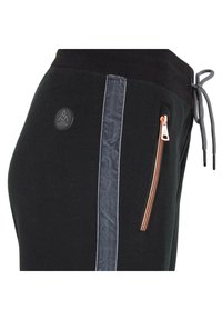 Pantalones deportivos negros con un bolsillo lateral con cremallera, franja lateral gris, tejido texturizado y un parche con el logo. Detalle del cinturón con cordón visible.