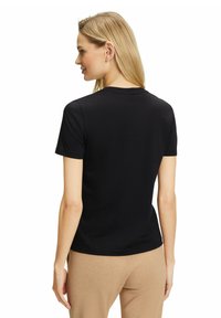 Czarna koszulka z krótkim rękawem, wykonana z gładkiego, elastycznego materiału z okrągłym dekoltem. Widok z tyłu pokazuje dopasowany krój i bezszwowe wykończenia.