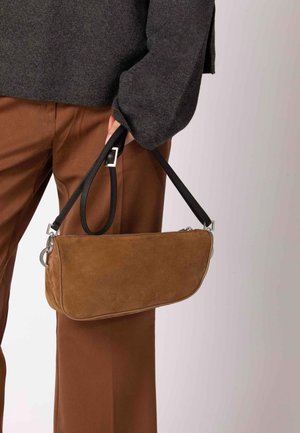 Pochette in camoscio marrone con tracolla in pelle nera, caratterizzata da un dettaglio in metallo argentato e logo del marchio in rilievo sulla parte anteriore.