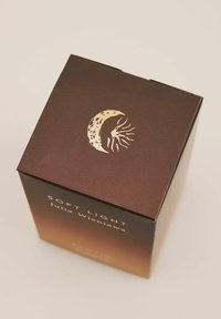 Brązowe opakowanie z metalicznym, złotym wzorem księżyca. Napis brzmi "Soft Light" oraz "Julia Wieniawa." Gładka tekstura z gradacyjnym wykończeniem.