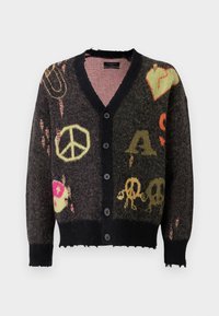 Cardigan de punto en gris oscuro con ribetes negros. Presenta patrones coloridos, incluyendo signos de paz y calaveras, con un borde ligeramente deshilachado.