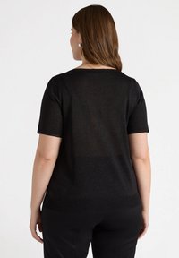 Czarny krótki top z krótkim rękawem wykonany z półprzezroczystego dzianinowego materiału, z okrągłym dekoltem i subtelnym efektem połysku.