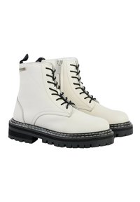 Botas de tobillo de cuero blanco con cordones negros, suelas de goma negra en contraste, costuras decorativas y cremallera lateral para facilitar su uso.