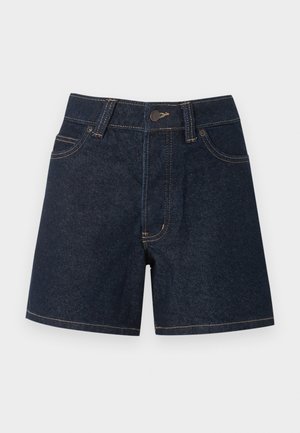 Sötétkék farmer rövidnadrág elöl gombbal, övhurkokkal és elülső zsebekkel, egyszínű világos háttér előtt.