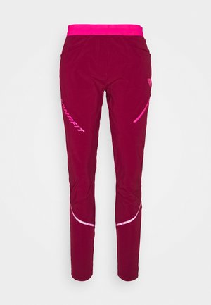 Mørke magentafarvede træningsbukser med lys pink elastisk taljebånd, sidelomme med lynlås, reflekterende detaljer og "Dynafit"-logo på låret.