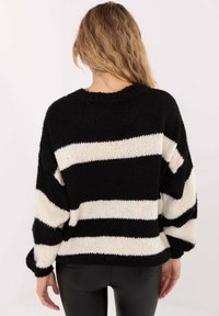 Schwarz-weiß gestreifter Pullover mit lockerem Schnitt, gerippten Bündchen und rundem Ausschnitt. Strukturierter Strickstoff, mittlere Dicke.