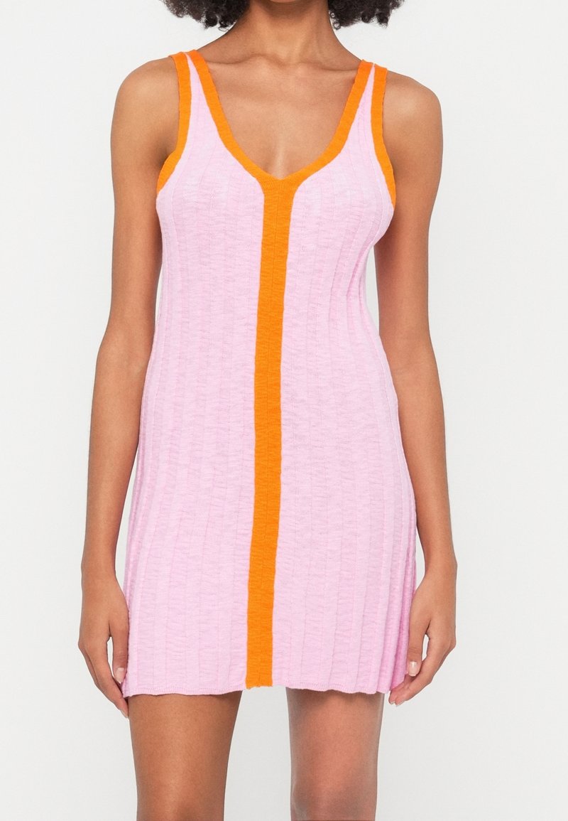 Mini-robe sans manches en maille côtelée rose clair avec bordure orange vif le long de l'encolure, des bretelles et de la couture centrale devant.