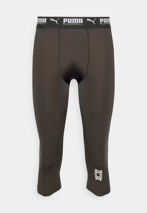Collants de compression marron foncé avec une taille élastique noire, présentant un logo et la marque "PUMA BASKETBALL" en blanc sur la jambe inférieure.
