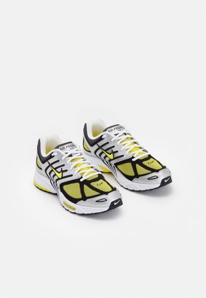 Par hvide, gule og sorte Nike Air Pegasus løbesko med mesh-paneler og snørebånd, vinklet let mod højre.