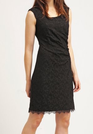 Robe en dentelle noire avec un corsage ajusté, sans manches, motif floral et ourlet festonné, mettant en valeur des détails texturés sur l'ensemble.
