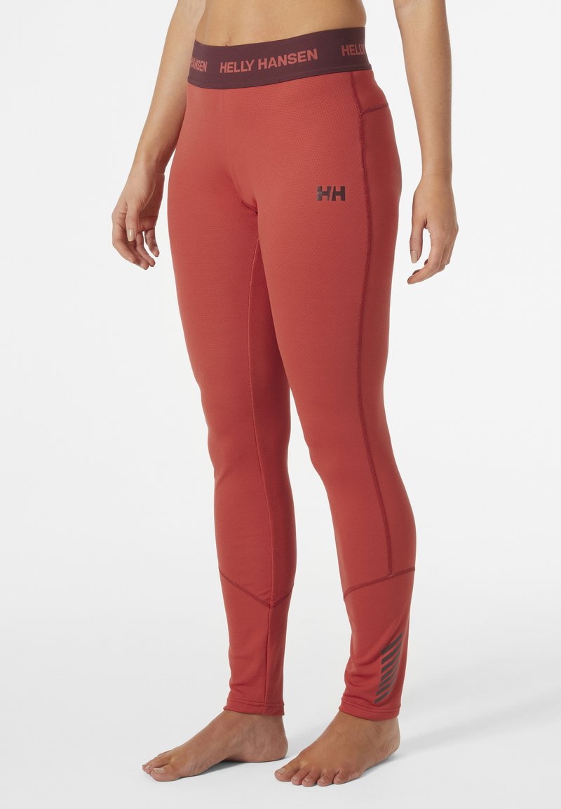 Leggings rojos elásticos con cintura alta, que presentan un sutil patrón texturizado y detalles en negro en los laterales. Logotipo de Helly Hansen en la cintura.