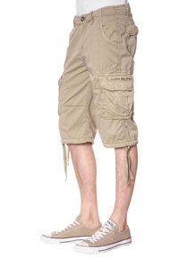 Bermuda cargo color khaki con molte tasche, polsini con cordoncino e un tessuto morbido e testurizzato. Abbinati a sneakers in tela beige chiaro.