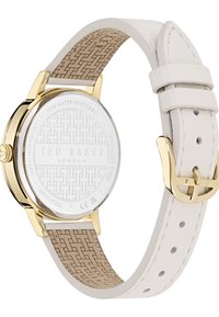 Orologio con cinturino in pelle bianca e cassa in acciaio inossidabile dorato, retro beige a motivo, quadrante trasparente e marchio inciso sul retro.