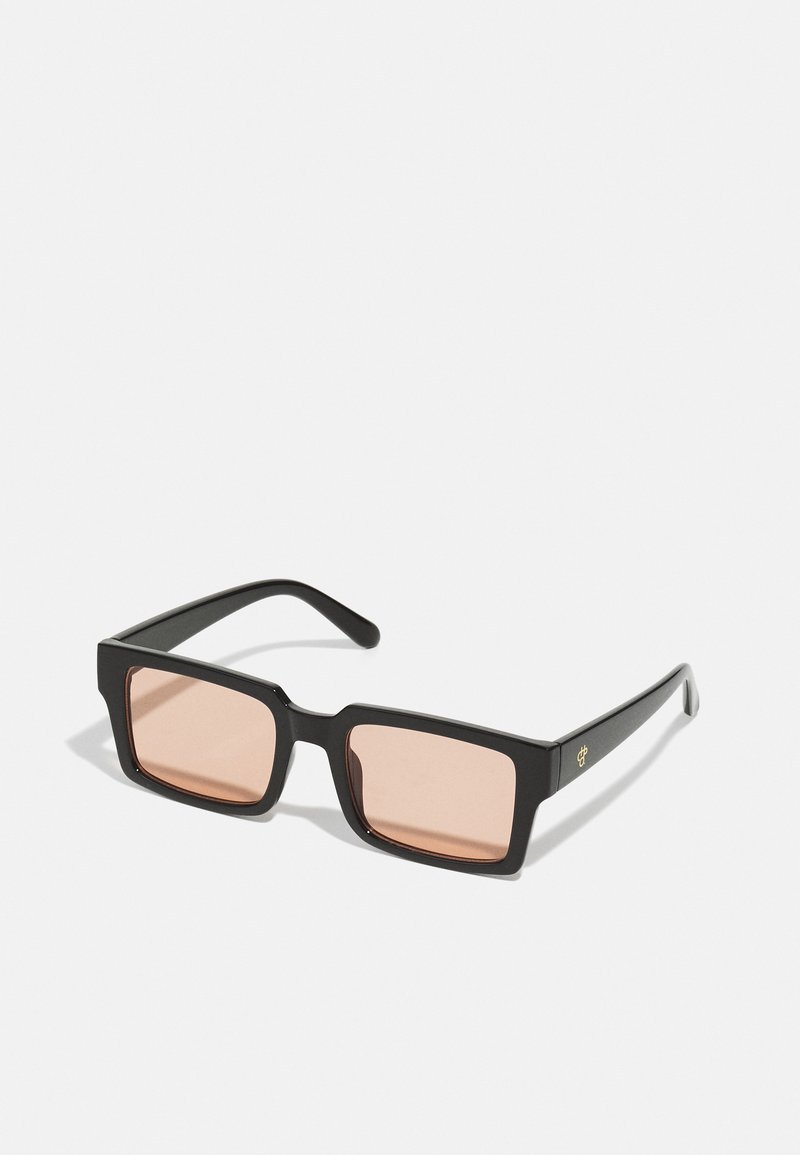 Ochelari de soare dreptunghiulari negri cu lentile roz. Au un cadru gros și un detaliu subtil cu logo auriu pe lateral. Finisaj din plastic neted.