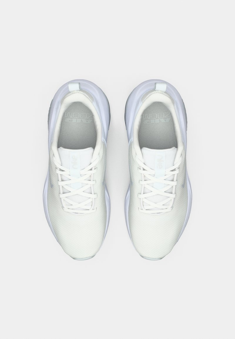 Hvide atletiske sko med en tekstureret mesh-overdel, flade snørrebånd og gummisåler. Har et minimalistisk design og en forstærket hæltab.