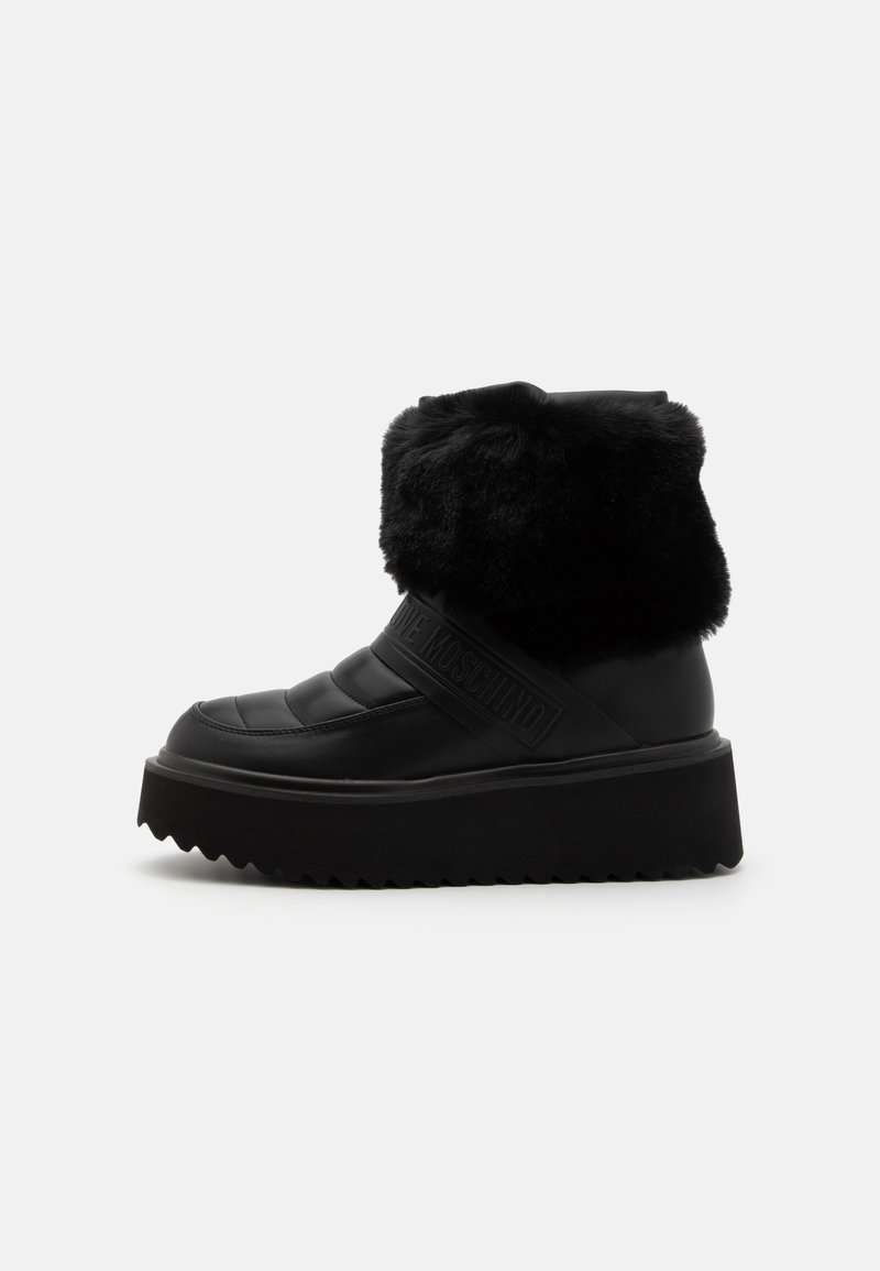 Botas negras hasta el tobillo con un cuello de piel, diseño acolchado, cuero suave y una suela gruesa y texturizada con acentos de patrón en zigzag.